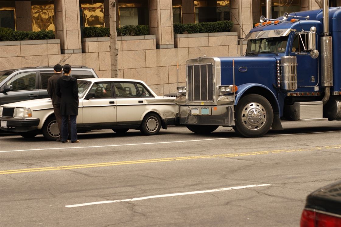 A semi truck towing a car

Description automatically generated